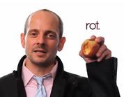 funny Monsanto video link; thumb of spokesman holding rotten apple