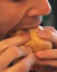 thumb of man biting sandwich