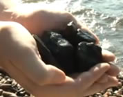 funny coal video link; thumb of lumps of coal in a man's hand's