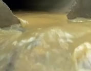 water pollution video link; thumb of polluted water flowing through rocks