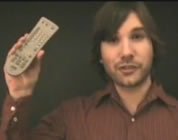 funny mainstream media video link; thumb of man holding TV remote control